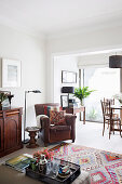 Brown leather armchair, side table, floor lamp and half-height cabinet in the living room