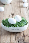 Cress and eggs in egg-shaped china pot