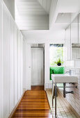 Sink, mirror cabinet above in white bathroom with parquet and tiled floor