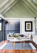 Bright upholstered sofa and coffee table in the living room with a gable roof