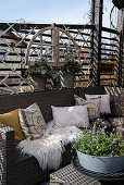 Ethnic-style cushions and fur rugs on outdoor sofa