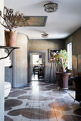 Painted board floor, houseplants and artworks in room with grey-brown walls