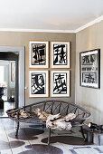 Vintage metal bench in corner of room with artworks on grey-brown walls