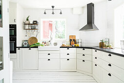 Light-flooded country-house kitchen with white board floor