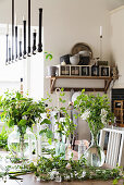 Vases of flowers and twigs on table in kitchen-dining room