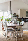 Various chairs around dining table in country-house kitchen