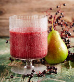 A glass of elderberry and pear smoothie with grapes