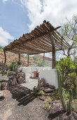 Masonry terrace below rustic pergola