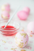Pink eggs with gold leaf and bowl of dye