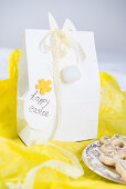 Easter bunny with lace ribbon on gift bag on yellow tissue paper