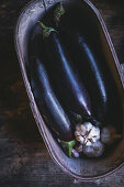 Eggplant and garlic in an elongated wooden bowl
