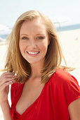 A blonde woman on a beach wearing a red top