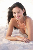 A young brunette woman wearing on a beach wearing a silver bikini top