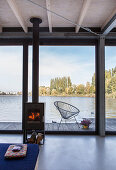 Modern houseboat: log-burner in front of glass wall