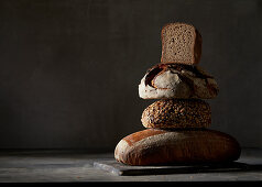 Four different breads, stacked in front of a dark background