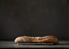 A baguette in front of a dark background