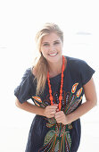 A young blonde woman with necklace wearing a beach dress