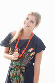 Junge blonde Frau mit Halskette im Strandkleid
