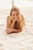 Blonde Frau am Strand liegend