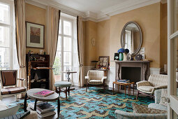 Fireplace, beige silk wallpaper and patterned carpet in living room