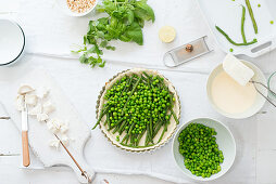 Pea tart with green beans and goat's cheese being made