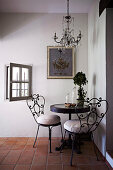 Small round table with nostalgic metal chairs in the corner of a country house