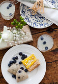 A brunch table with lemonade with blueberries, lemon tart and blueberry scones