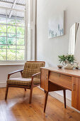 Retro dressing table and upholstered armchair in corner of room