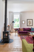 Kaminofen und Sofas, lila Samt und lindgrün im Wohnzimmer