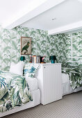 Single beds and wallpaper with leaf motif in the bedroom