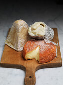 Three soft cheeses on a wooden board