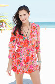 A young woman on a beach wearing a floral dress