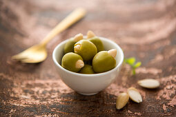 A bowl of green olives filled with almonds