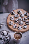 Chocolate crinkle cookies served on a wooden board and ceramic plate in festive Christmas styling