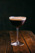 Espresso martini cocktail on dark wooden background