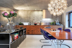 Blaue Designerstühle am Esstisch in moderner offener Wohnküche