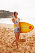 A girl with a surfboard on a beach