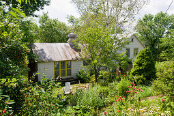 Idyllic cottage with chimney in summery garden