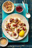 Curry-colored eggs filled with lentils, nuts and pomegranate seeds