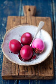 Mit Rote-Bete-Saft rot gefärbte hartgekochte Eier