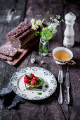 Haselnussbrot mit Avocadoscheiben und Tomaten und eine Tasse Tee