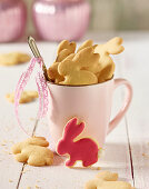 Rabbit shaped biscuits in a coffee cup on a white wooden table