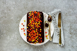 A small chocolate cake with colourful chocolate pearls