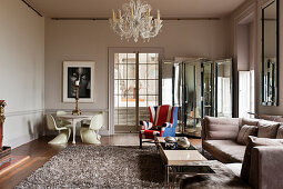 Murano chandelier in drawing room with classic chairs and a union jack upholstered winged back armchair