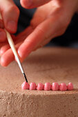 Cream dot points being flattened with a brush