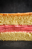Pink buttercream between layers of sponge cake