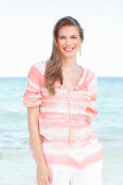 A young woman by the sea wearing a striped blouse