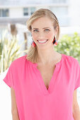 A blonde woman wearing a pink blouse