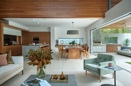 Open living room with sliding glass element to the terrace with outdoor kitchen