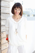 A brunette woman wearing a white long-sleeved blouse